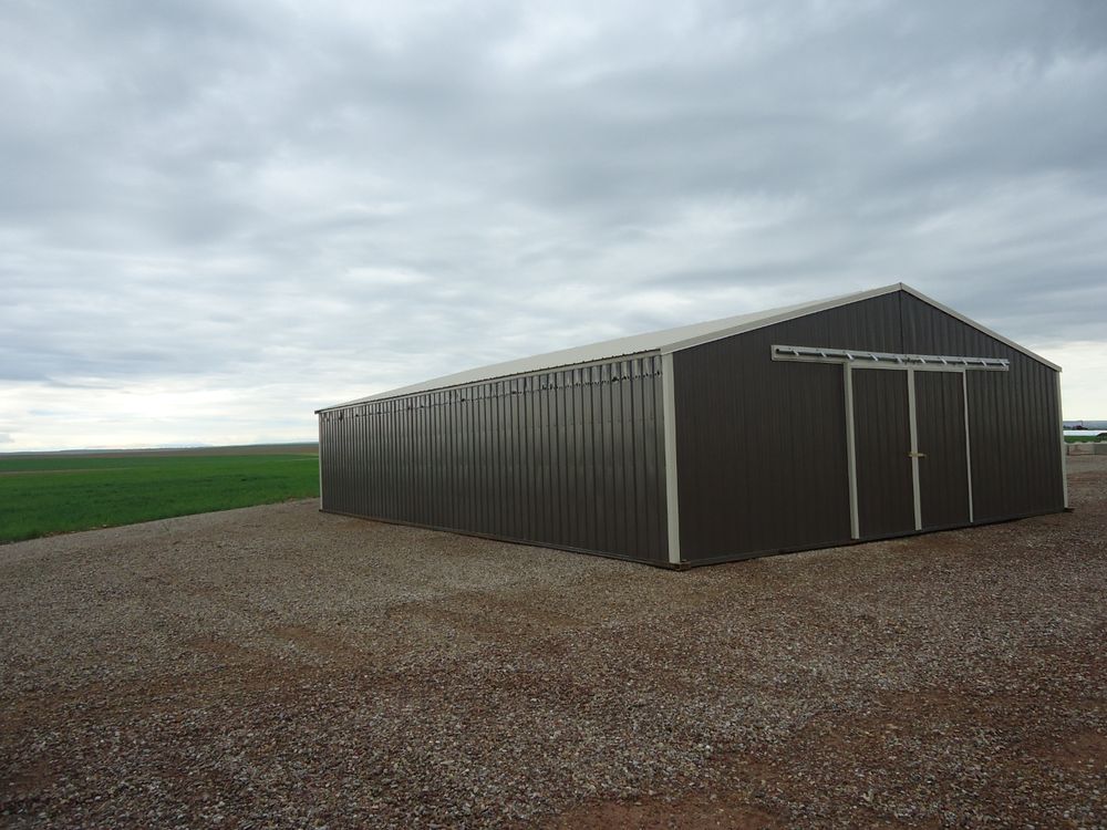 Exterior three quarter view of the in-stock 34 by 48 foot enclosed calving barn in burnished slate with light stone trim